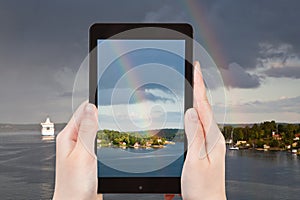 Tourist photographs of rainbow over Baltic sea