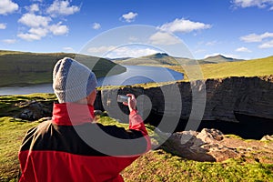 Tourist photographs view of Lake Leitisvatn or Sorvagsvatn, Faroe Islands