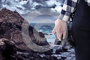 Tourist or Photography Hobbyist Holding Camera at the Coastline