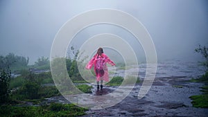 Tourist with pink rain coat Stand View the scenery natural beautiful touch fog at Phu Hin Rong Kla National Park. travel nature,