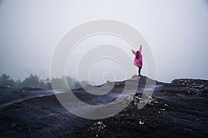 Tourist with pink rain coat Stand View the scenery natural beautiful touch fog at Phu Hin Rong Kla National Park. travel nature,