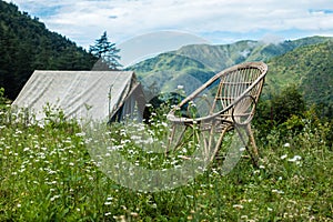 An tourist place in the meadows with a camp and a bamboo chair with mountains in the background. Uttarakhand India