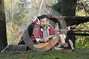 Tourist Playing Guitar in the Woods