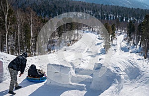 Tourist playing snow tubing in Listvyanka a small town in Irkutsk Oblast on the shores of Lake Baikal.