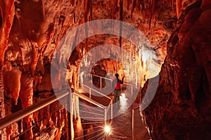 Tourist pointing a flashlight at stalactites.
