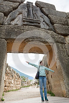 Tourist posing under famous Lion gate entrance.