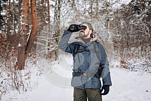 A Tourist Ranger in Anorak Using Binoculars