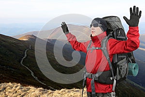 Tourist in red jacket on the elephant mountain with the hands lifted upwards