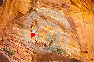 Tourist among red rocks in Zion National Park