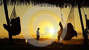 Tourist relaxing in hammocks during sunset at Madidi National Park in Bolivia.