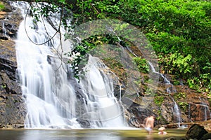 Tourist relaxing under flowing waterfall nature. Nature Therapy.