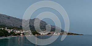 Tourist resort Baska Voda on the Adriatic coast under the mountain Biokovo in Croatia, at dusk in summer