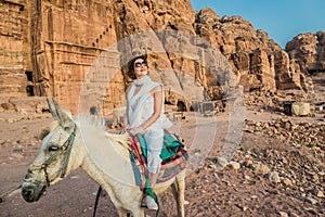 Tourist riding donkey in nabatean city of petra jordan photo