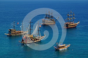 Tourist sailboats in turquoise waters of the Mediterranean sea beside the Turkish ancient fortress Alanya. Antalya