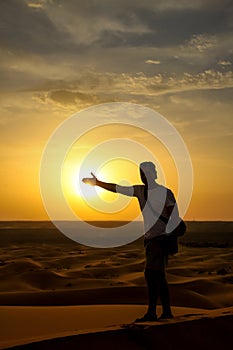 Tourist on a sand dunes at sunset