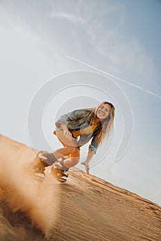 Tourist Sandboarding girl In the Desert Man jumps in and does the trick