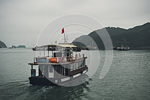 Tourist ship sailing among floating fisherman  village in ha long bay,