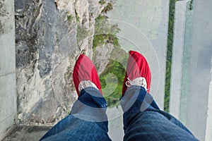 Tourist in shoe covers on glass pathway in Tianmenshan nature pa