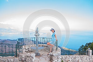 Tourist sightseeing coin operated telescope on the cliffs used for looking out into the sea.tourist Telescope and woman