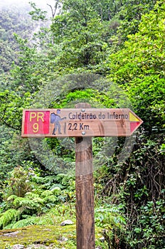 Tourist sign giving directions and distances on a hiking path in Caldeirao de Inferno, Madeira island, Portugal. Levada walking on