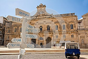 Tourist signpost with distances and in the background the Municipality of Ostuni Italy photo