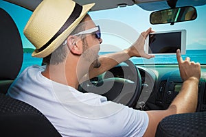 Tourist sitting at driver seat and using digital tablet device