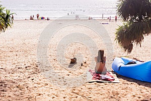 Tourist sitting for taking a rest at `Kata Noi` beach, Phuket, Thailand