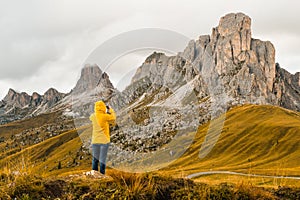 A tourist snaps photos of meadows nestled in the picturesque Alpine mountain range