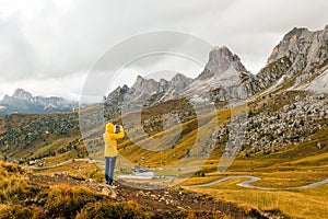 A tourist snaps photos of meadows nestled in the picturesque Alpine mountain range