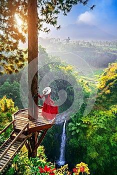 Tourist standing at Air Terjun Kedung Kayang waterfall at sunrise, Indonesia