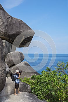 Tourist standing on cliff and photographs the landscape. Thailand