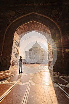 tourist standing in front entrance gate of Taj Mahal indian palace. Islam architecture. Door to the mosque