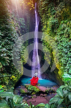 Tourist standing at Leke Leke waterfall in Bali, Indonesia