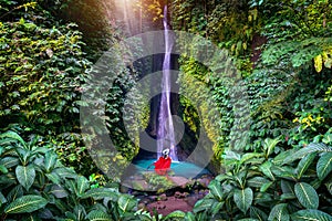 Tourist standing at Leke Leke waterfall in Bali, Indonesia