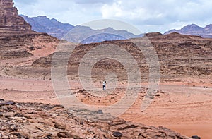A tourist stands on a hill and takes a Wadi Rum desert photo on his mobile phone near Aqaba city in Jordan