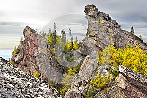 A tourist stands on a rock and admires the picturesque view