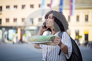 Tourist on street with map and talking on phone