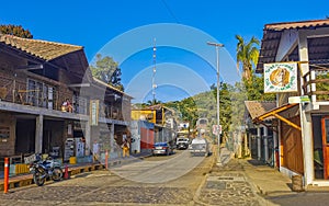 Tourist street restaurants houses people cars hotels stores Mazunte Mexico