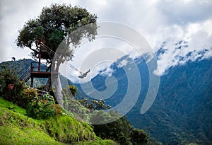 Tourist swinging on the swing of the end of the world Columpio del fin del mundo in BaÃÂ±os, Ambato province, Ecuador. photo