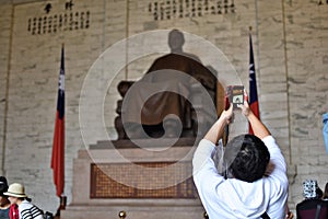 A tourist takes a photo of a monument