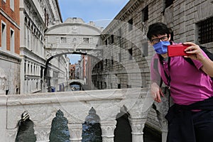 Tourist takes a selfie with the Bridge of Sighs behind him