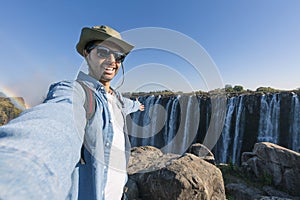 A tourist takes a selfie at Victoria Falls on the Zambezi River, located on the border between Zambia and Zimbabwe, the largest