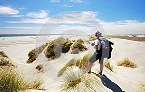 Tourist taking photo of Farewell spit sand dunes