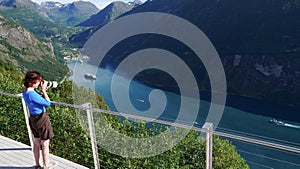 Tourist taking photo of fjord landscape, Norway