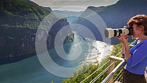 Tourist taking photo of fjord landscape, Norway