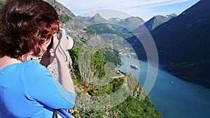 Tourist taking photo of fjord landscape, Norway