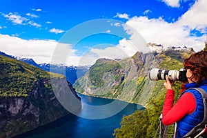 Tourist taking photo of fjord landscape, Norway