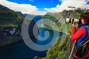 Tourist taking photo of fjord landscape, Norway