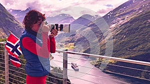 Tourist taking photo of fjord landscape, Norway