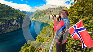 Tourist taking photo of fjord landscape, Norway